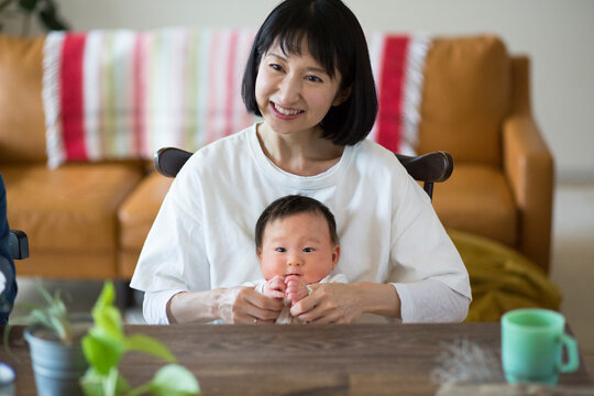 あかちゃんを膝の上に座らせている母親