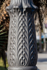 Detail of a chic silver street lamp on the streets of Madrid. Floral street lamp ornament shining of the sunlight.
