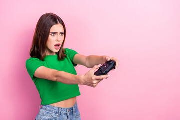 Photo of pretty impressed girl open mouth hold controller look empty space isolated on pink color background