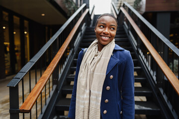 Portrait of smiling young black woman standing in the street