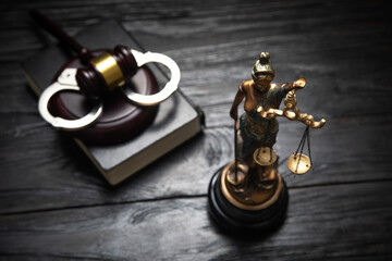 Naklejka premium Statue of Lady Justice, handcuffs, book and gavel.