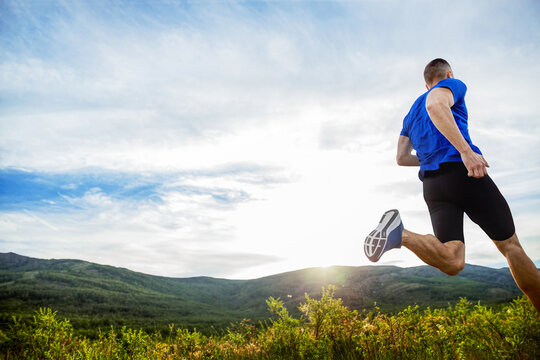 Back Athlete Runner Run Mountain Meadow In Rays Of Sunset