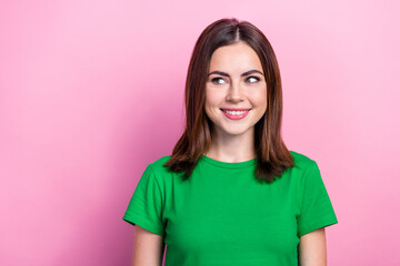 Fototapeta premium Portrait of good mood girlish nice woman with straight hairdo wear green t-shirt look empty space isolated on pink color background