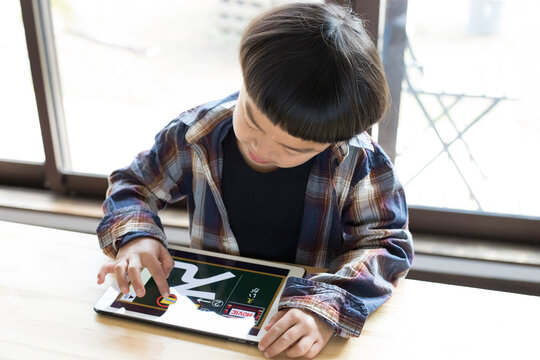 タブレットでひらがなを練習する男の子