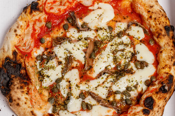 Close up of a Sicilian pizza with anchovies, capers and olives