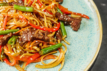 fried wok beef noodles on a black rustic background
