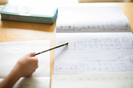 えんぴつで漢字のテキストを指し示す子供の手元