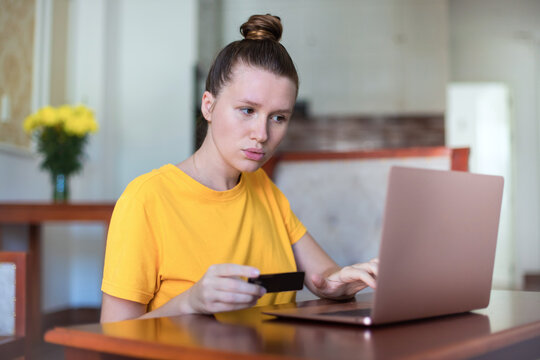 Serious Woman Entering Information From Credit Bank Card On Laptop At Home, Online Shopping