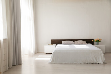 Fototapeta na wymiar Double bed in bright bedroom room interior furnishing furniture