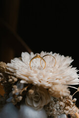 Detailed gold wedding ring on beautiful raindrops background