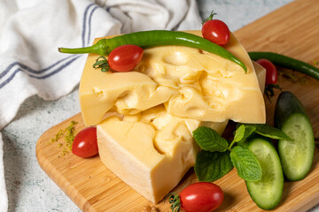 Gruyere cheese. Piece of Gruyere cheese on wooden cutting board. Cheese collection