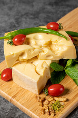 Gruyere cheese. Piece of Gruyere cheese on wooden cutting board. Cheese collection