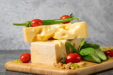 Gruyere cheese. Piece of Gruyere cheese on wooden cutting board. Cheese collection