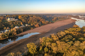 Aerial view of houses along the Loire river with sandbanks at sunset in Gennes, Maine-et-Loire, France.