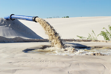 dirty water is poured from an industrial pipe into the environment, environmental pollution, sand...