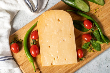 Gouda cheese. Piece of gouda cheese on wooden cutting board. Cheese collection. Ripe hard cheese made from cow's milk in the Netherlands. Top view