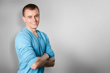 Happy young man posing on background