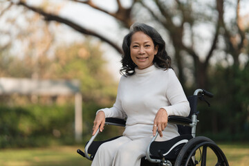 Obraz premium Happy senior asian women in wheelchair at home garden. Older asian woman have good healthy