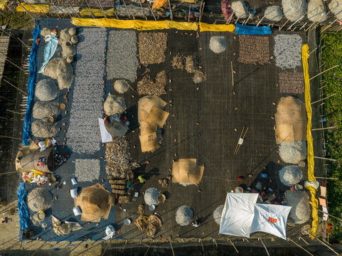 Aerial view of people working in a fish market drying fish at Lalpur Launch Ghat along Meghna River, Chattogram, Bangladesh.