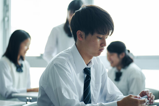 休み時間に教室で暗記をする男子高校生