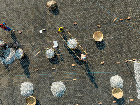Aerial view of people working in a fish market drying fish at Lalpur Launch Ghat along Meghna River, Chattogram, Bangladesh.