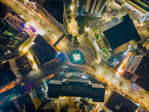 Aerial view of a roundabout with a lily point water fountain at night in Dhaka, Bangladesh.