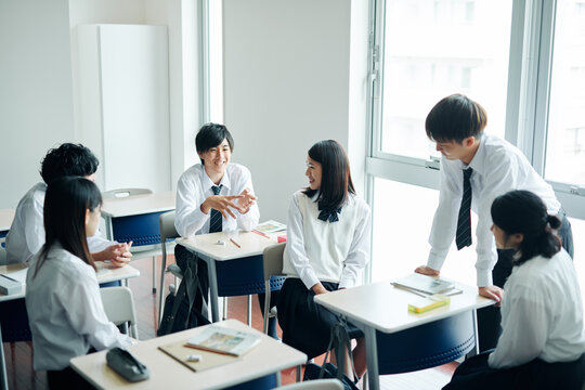 休み時間に教室で雑談する高校生