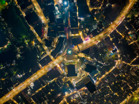 Aerial view of a roundabout with a lily point water fountain at night in Dhaka, Bangladesh.