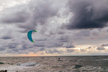 man at sea parachute in storm sky in clouds of nature