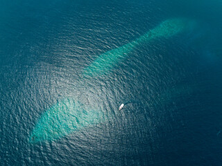 Aerial view of a sailing boat navigating on the Indian Ocean, Maldives archipelagos.