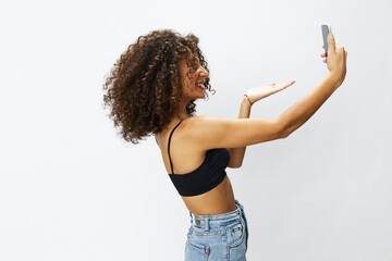 Woman blogger with phone in hand on white background selfies, video call, freelancer influencer job in social media and media, technology for work, smile curly hair copy spot