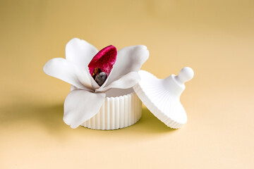 White trinket box with white orchid on soft beige background 