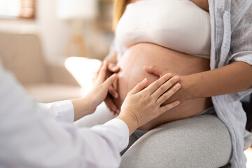 Happy Asian pregnant woman with her doctor in the examination room