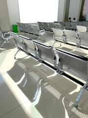comfortable metal rows of seats in bright airport lounge, Airport waiting room, concept passenger traffic, delay, flight cancellation, arrival time, international voyage, modern furniture