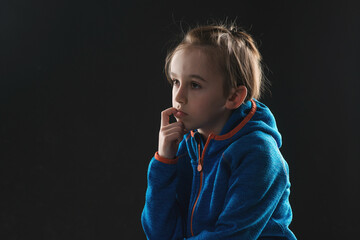 Little boy biting his nails. Sad child thinking about his problems. Emotional child portrait....