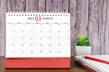 The March 2023 Monthly desk calendar for 2023 year with open diary wooden background.