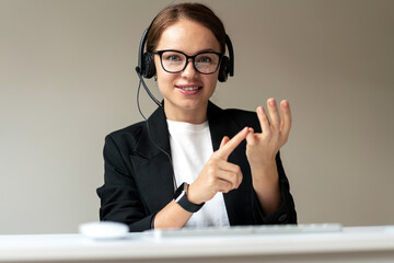 Online video call with personal development coach, woman in glasses and headset looking at webcam...