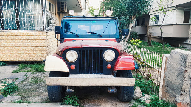Izmir, Turkey - Dec 23, 2022: Red motor car Jeep CJ-7 in the city street