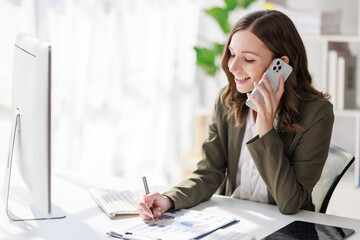 Concept of business investment or working woman,  Businesswoman wearing a suit sitting and working on analysis of business investment documents and using smartphone talk to client about business data.