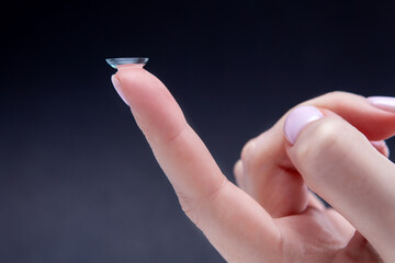 Soft contact lenses on a woman's finger, close-up. The concept of medicine and vision. Woman inserting a soft contact lens into her eye