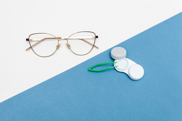 Contact lenses and glasses with a case, tweezers on a blue and white background