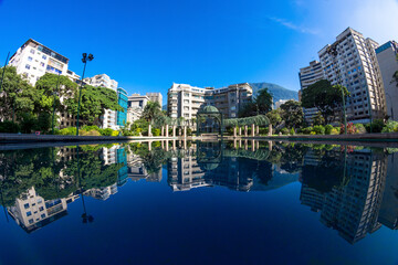 Naklejka premium North view of Plaza Altamira in Chacao, Caracas Venezuela. Reflecting pool showing Edificio Altamira, one of the oldest buildings in the area. 