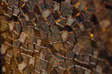 Close up photo of stained glass window under sunlight, it's shining amber colours on the light.