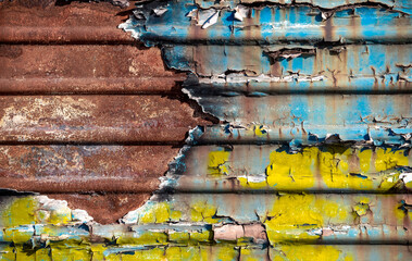pattern rusty metal surface with remnants of blue and yellow paint paint