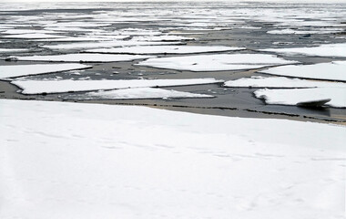 Landscape with melting broken ice floes floating on the river view till horizon