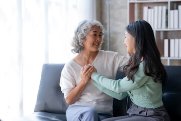 Fototapeta premium Asian mother and son spending vacation in living room Show your love for each other by embracing each other warmly and happily at home.