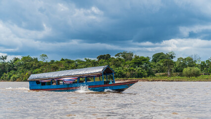 Fototapeta premium A motorized wooden boat underway on the Amazon River