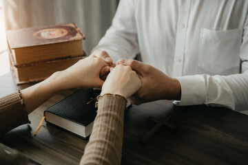 Obraz premium Asian men and women hands praying to god with the bible. Pray for god blessing. Religious beliefs Christian life crisis prayer to god.