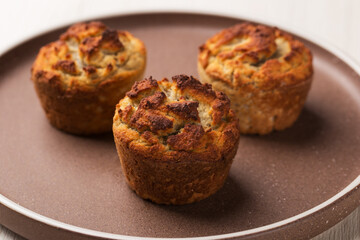 Homemade keto diet muffins with coconut flour on ceramic plate ready to eat. Healthy breakfast.