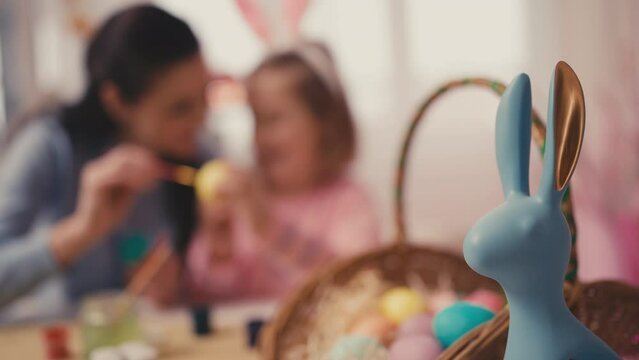 Woman and her daughter decorating Easter eggs at home, Christian traditions